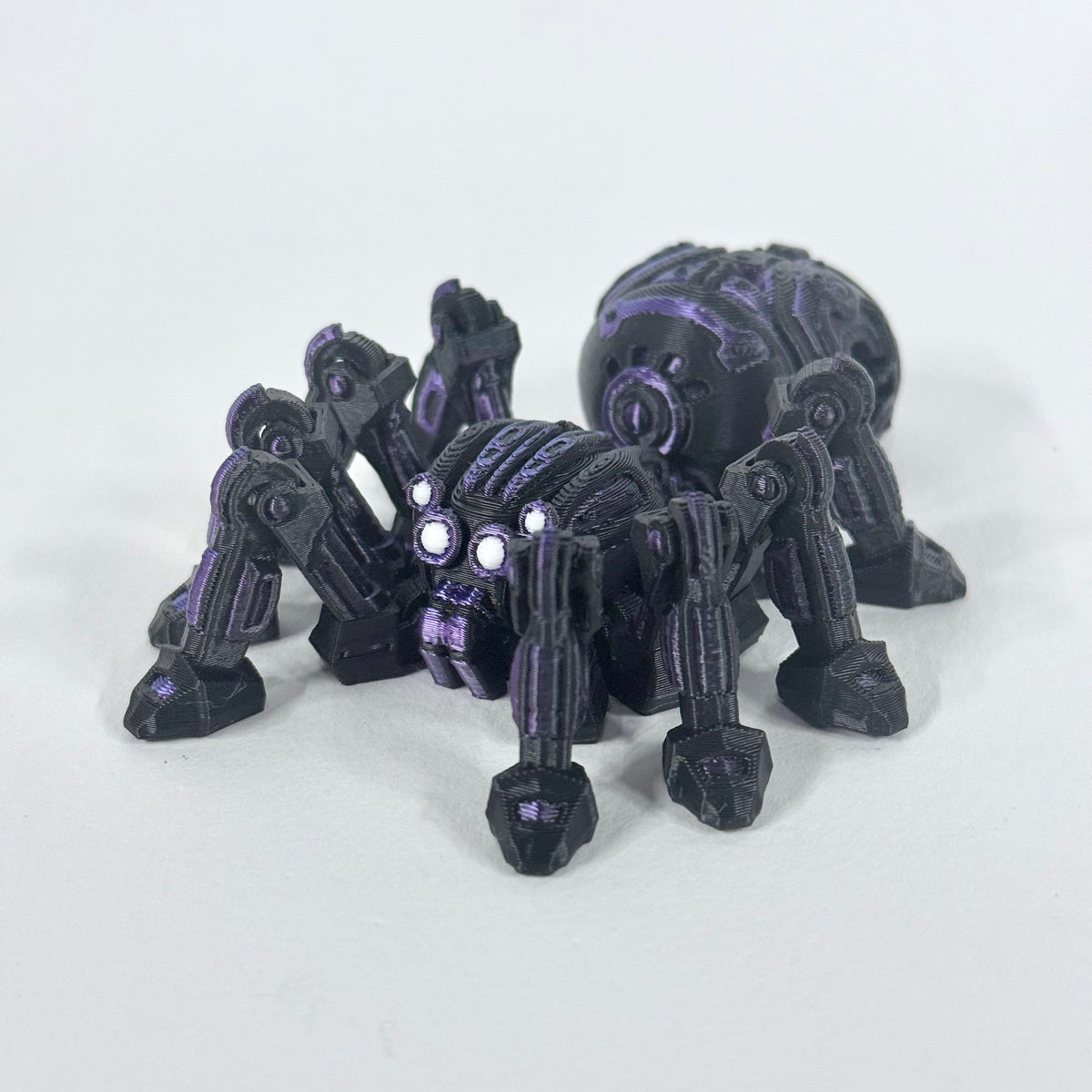Cyber Spider photographed from a front three-quarter angle, showing its articulated legs and purple detailing on the black body.