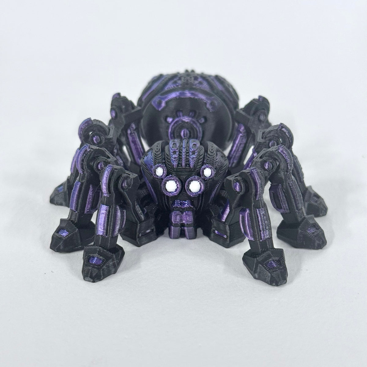 Cyber Spider shown from the front, with its articulated legs, bright eyes and purple detailing visible on the black body.
