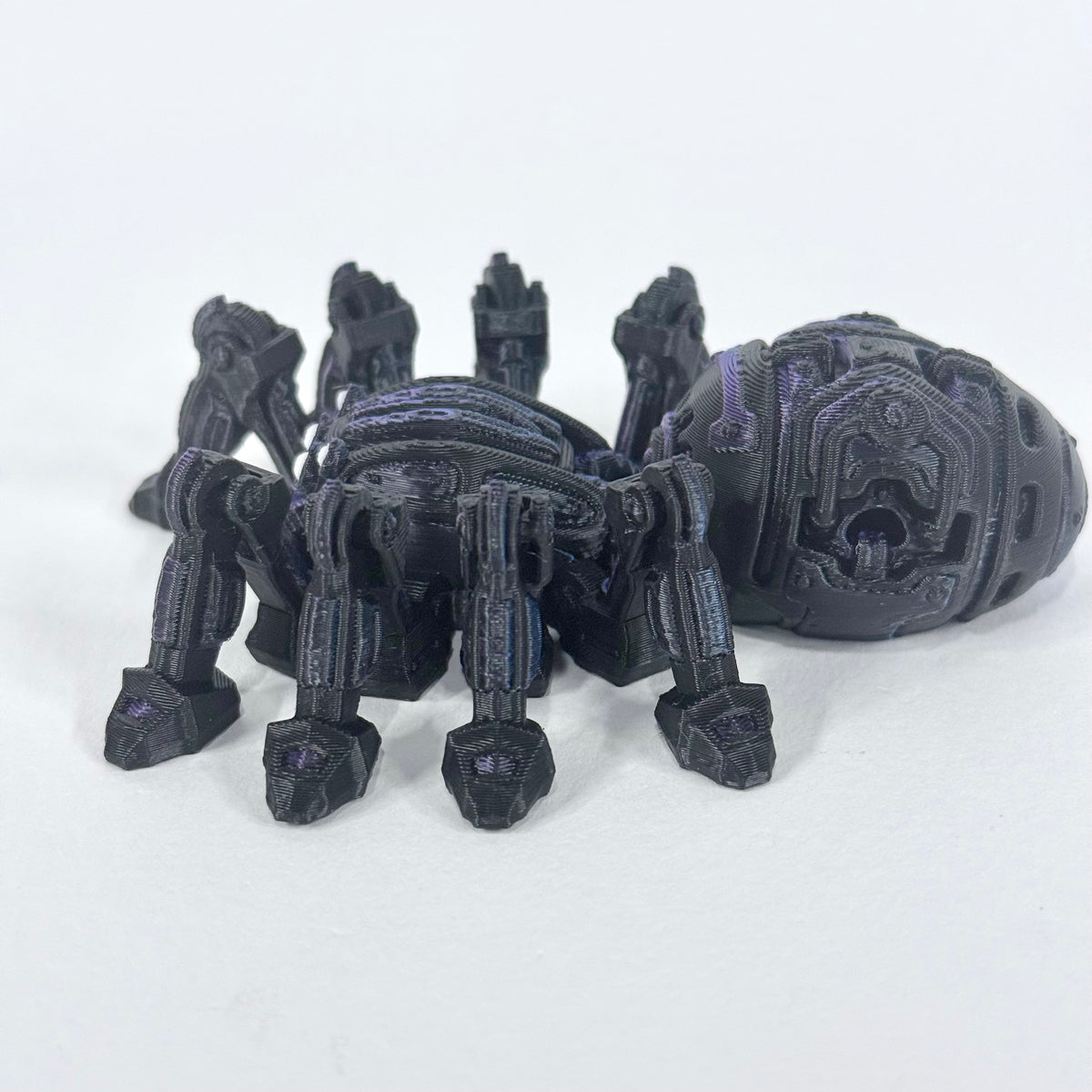 Cyber Spider shown from the side, with its articulated legs, rounded body and purple detailing visible against a light background.