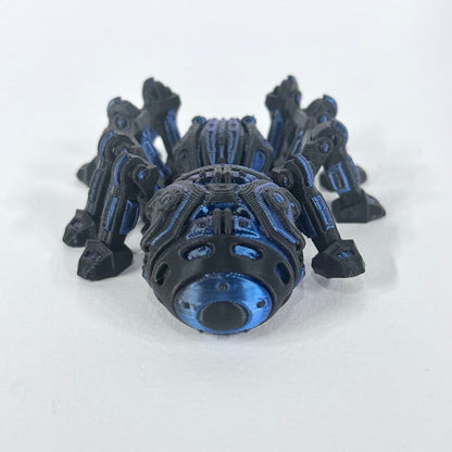 Cyber Spider photographed from above, showing the articulated leg layout and contrasting blue and purple accents on the black body.